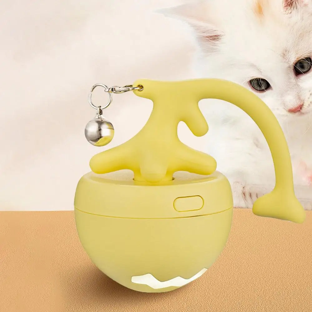 Yellow rolling cat toy ball with bell next to a kitten